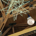 Super size straw star hanging in a building lobby