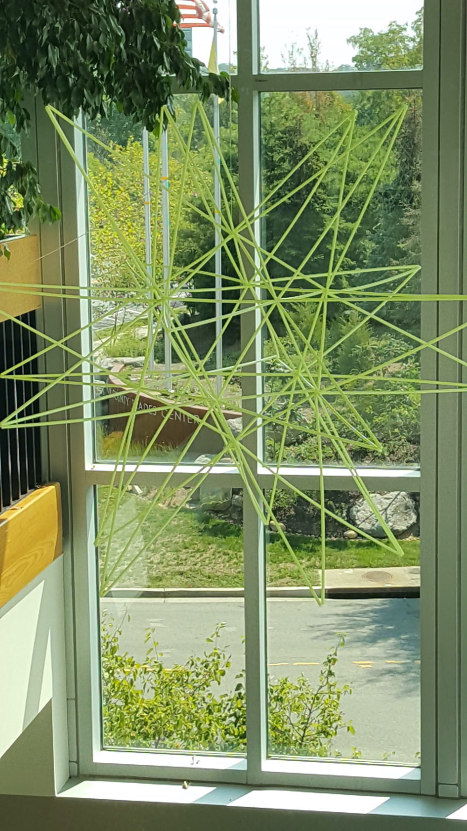 Super sized straw star hanging in front of a window